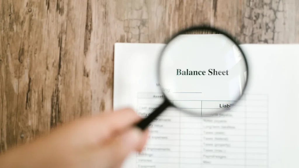 Balance financiero analizado con una lupa para calcular el EBITDA de una pyme