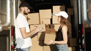 Personal de reparto organizando paquetes en un vehículo de transporte
