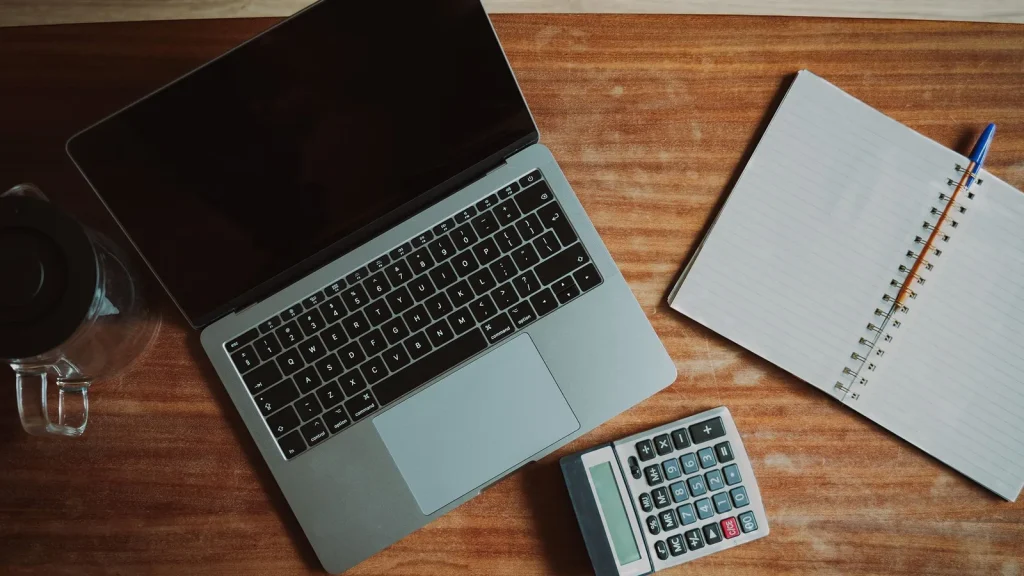 Escritorio con portátil y calculadora para comparar nóminas y pagas extra